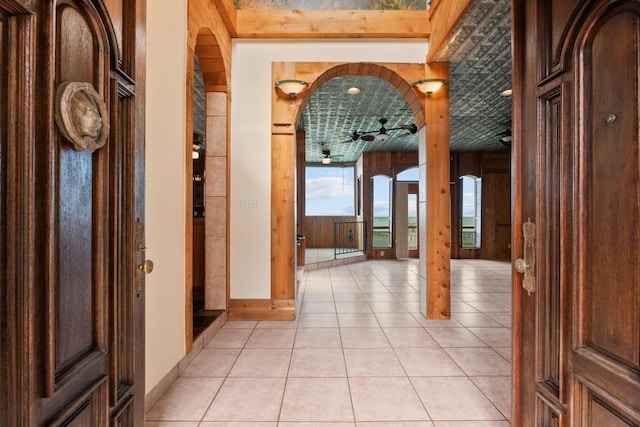 hallway featuring light tile patterned floors and arched walkways