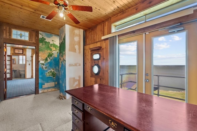 unfurnished office with wooden ceiling, a ceiling fan, and wood walls