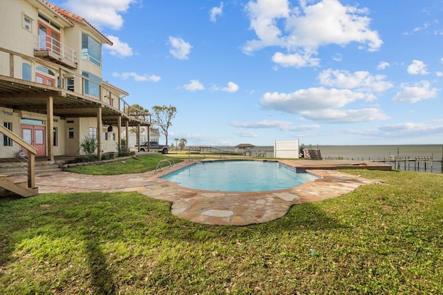 outdoor pool with a yard and a patio area