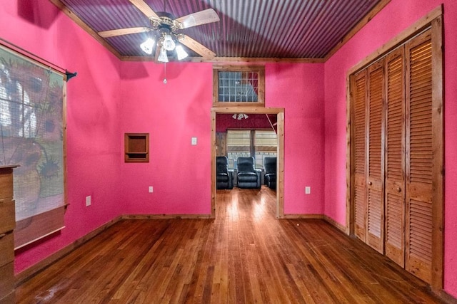 interior space featuring baseboards, wood finished floors, and ceiling fan