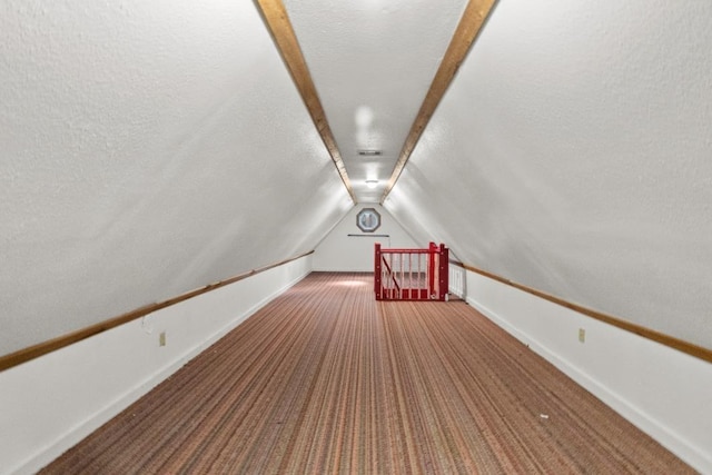 bonus room featuring visible vents, baseboards, lofted ceiling, a textured ceiling, and carpet flooring