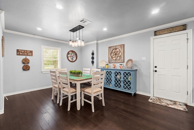 dining area with hardwood / wood-style flooring, crown molding, baseboards, and visible vents