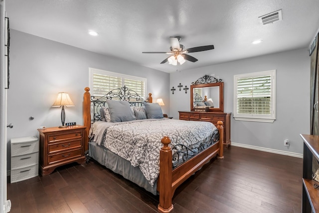 bedroom with dark wood-type flooring, multiple windows, and visible vents