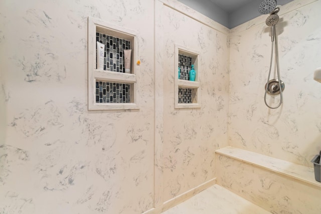 bathroom featuring baseboards and a tile shower