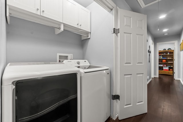 clothes washing area with dark wood-type flooring, washer and clothes dryer, cabinet space, baseboards, and attic access