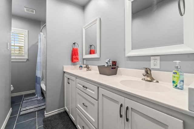 full bath featuring tile patterned flooring, baseboards, toilet, double vanity, and a sink