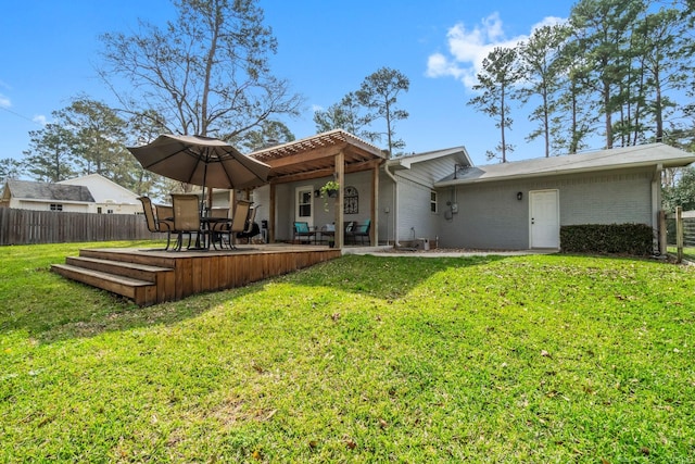 rear view of house with a yard and fence