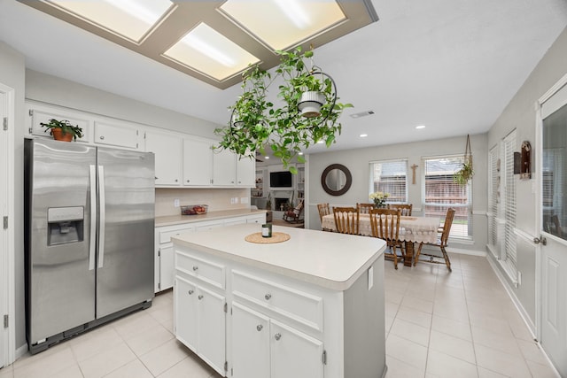 kitchen featuring light countertops, light tile patterned flooring, visible vents, and stainless steel fridge