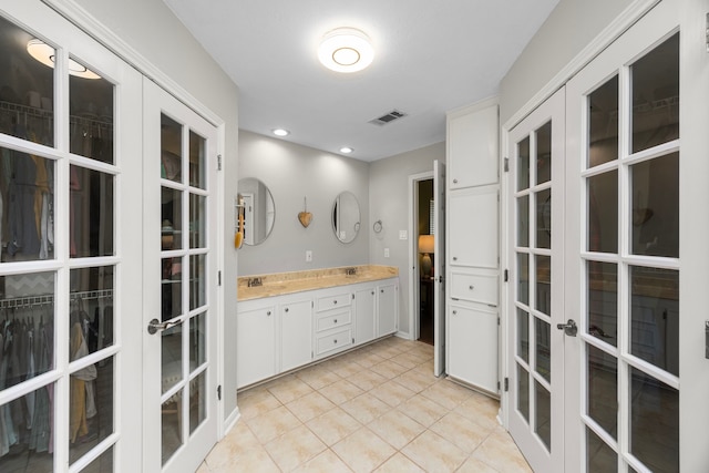 bathroom with visible vents, recessed lighting, french doors, tile patterned flooring, and double vanity