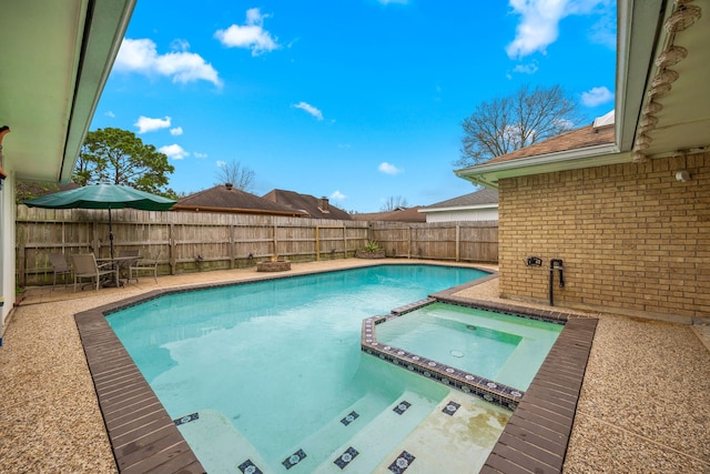 view of swimming pool with a patio area, a fenced backyard, and a pool with connected hot tub