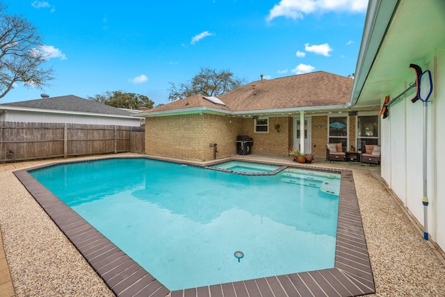 view of swimming pool featuring grilling area, a pool with connected hot tub, a patio, and fence