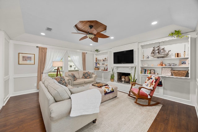 living room featuring visible vents, a ceiling fan, dark wood finished floors, recessed lighting, and a brick fireplace