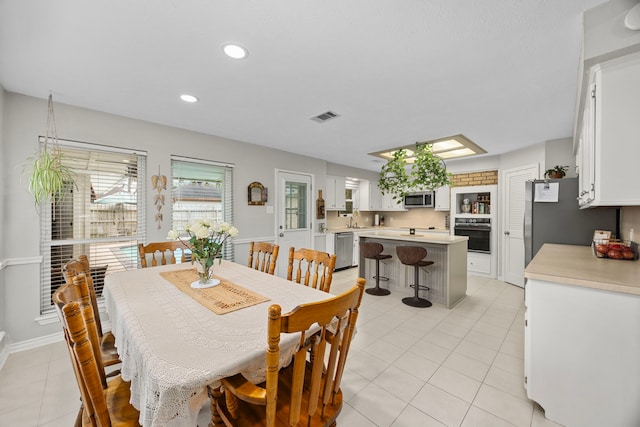 dining room with light tile patterned flooring, visible vents, and recessed lighting