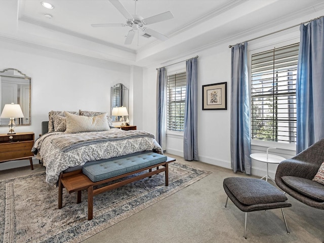 bedroom with a tray ceiling, carpet floors, baseboards, and crown molding