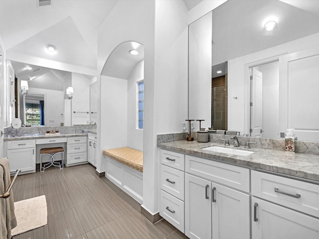 bathroom with visible vents, lofted ceiling, vanity, and a shower stall