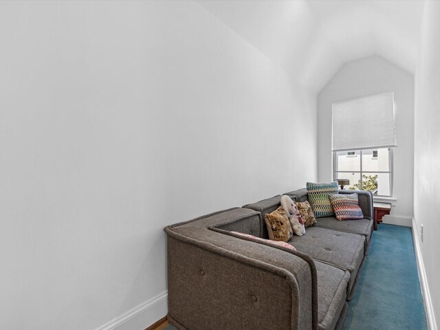 living area with baseboards, lofted ceiling, and carpet