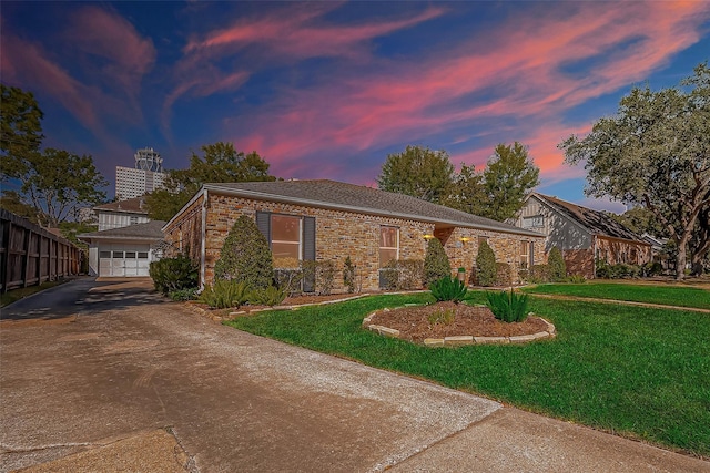 view of front of house with brick siding, fence, concrete driveway, a lawn, and a garage