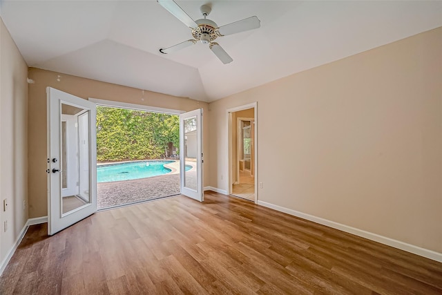 unfurnished room with vaulted ceiling, baseboards, ceiling fan, and wood finished floors