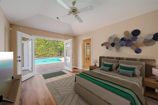 bedroom with ceiling fan, vaulted ceiling, wood finished floors, ensuite bath, and access to outside