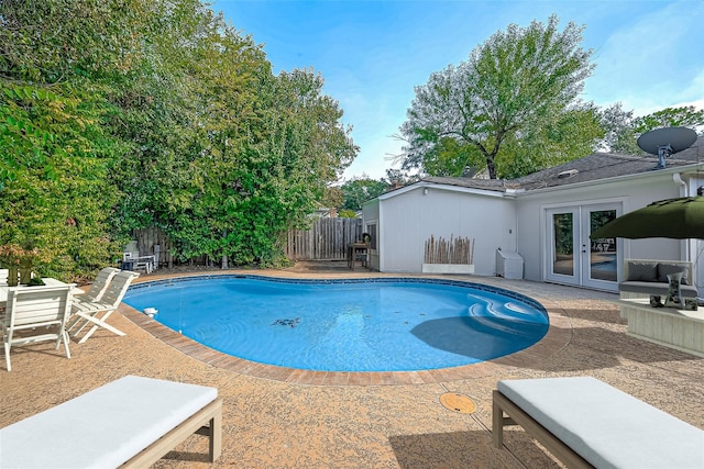 view of pool with french doors, a fenced in pool, a fenced backyard, and a patio area