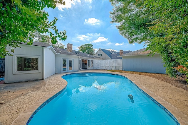 view of pool featuring a patio area, a fenced in pool, french doors, and fence