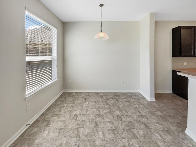 unfurnished dining area with baseboards