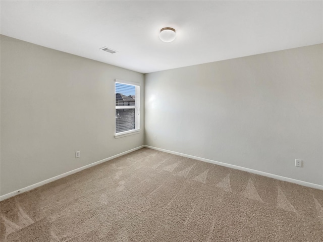 spare room with light carpet, visible vents, and baseboards