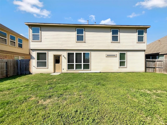 rear view of property with a lawn and a fenced backyard