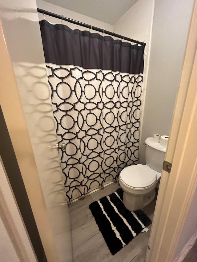 bathroom with curtained shower and toilet