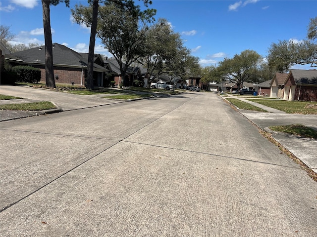 view of street featuring curbs, a residential view, and sidewalks