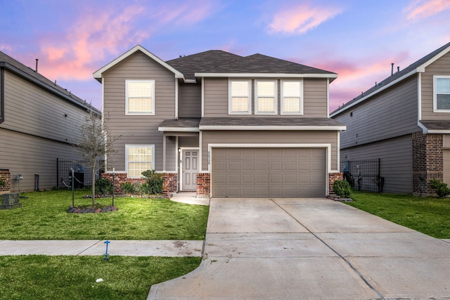 traditional home with a lawn, fence, concrete driveway, an attached garage, and brick siding