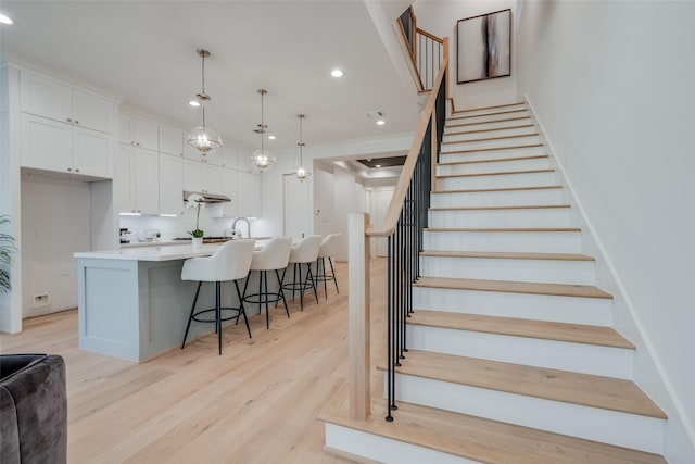 stairs with recessed lighting and wood finished floors