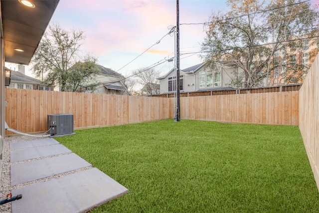 view of yard featuring central AC unit and a fenced backyard