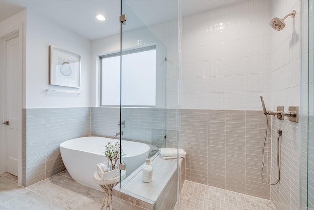 full bath with tile walls, recessed lighting, a tile shower, and a freestanding bath