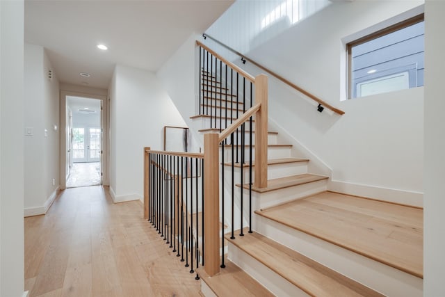 staircase with recessed lighting, baseboards, and wood finished floors