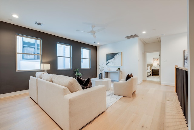 living room with visible vents, light wood-style flooring, attic access, and baseboards