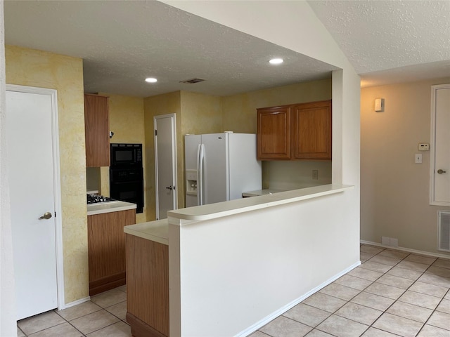 kitchen with black appliances, a textured ceiling, brown cabinetry, light countertops, and light tile patterned floors