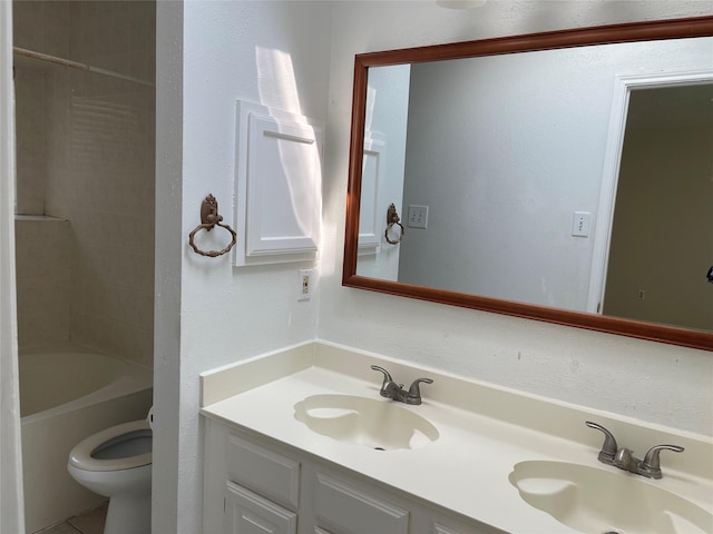 bathroom with double vanity, toilet, and a sink