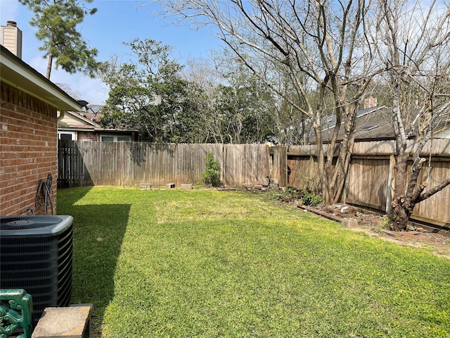 view of yard with central AC unit and a fenced backyard