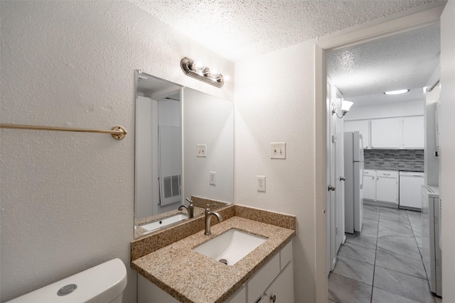 half bath featuring decorative backsplash, a textured ceiling, toilet, and a textured wall