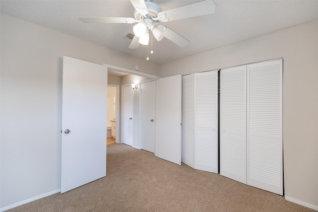 unfurnished bedroom featuring visible vents, light colored carpet, a closet, and a textured ceiling