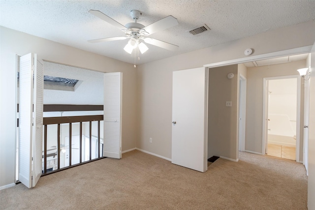 unfurnished bedroom with visible vents, carpet floors, a textured ceiling, and baseboards