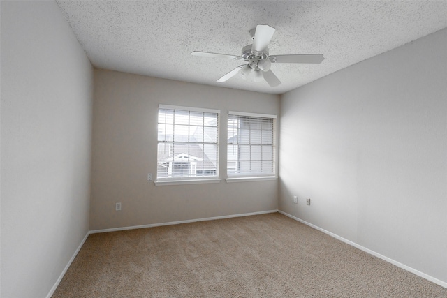 unfurnished room featuring baseboards, light colored carpet, a textured ceiling, and ceiling fan