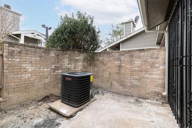 details with central air condition unit, fence, and brick siding