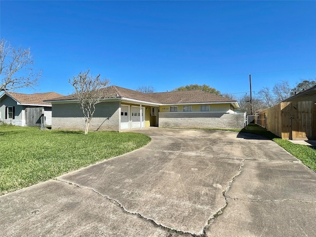 view of front of home with a garage, concrete driveway, a front yard, and fence