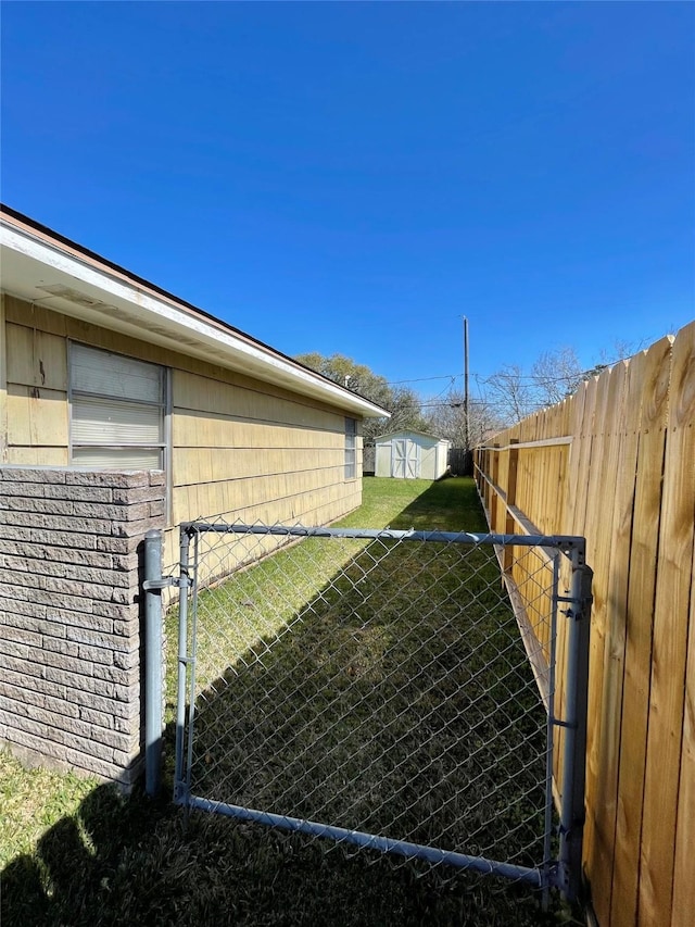 view of yard with a gate, an outbuilding, and fence