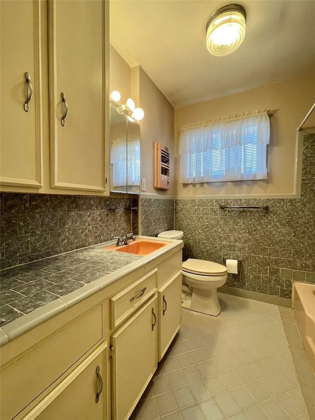 full bath with tile walls, toilet, wainscoting, heating unit, and vanity