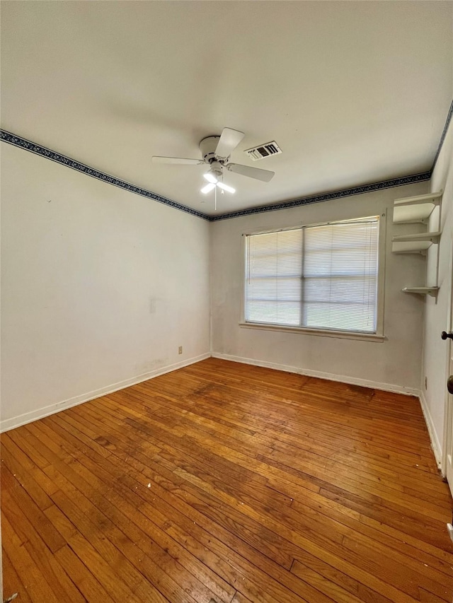 empty room featuring visible vents, baseboards, ceiling fan, and wood-type flooring