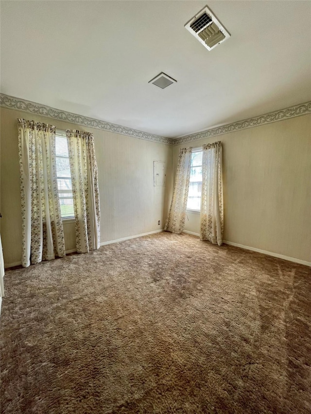 unfurnished room with wallpapered walls, carpet flooring, and visible vents