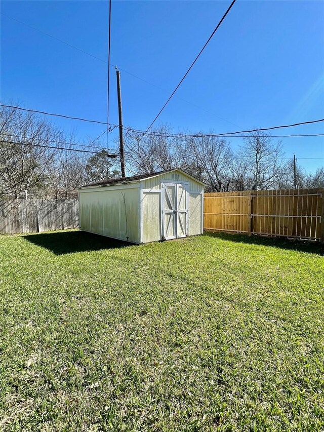 view of yard featuring an outdoor structure, a storage unit, and fence